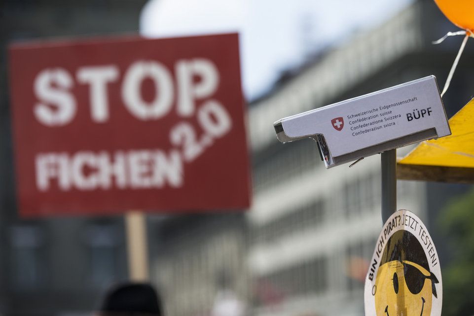 Ein Aufkleber der Piratenpartei klebt unter einem Modell einer Ueberwachungskamera.